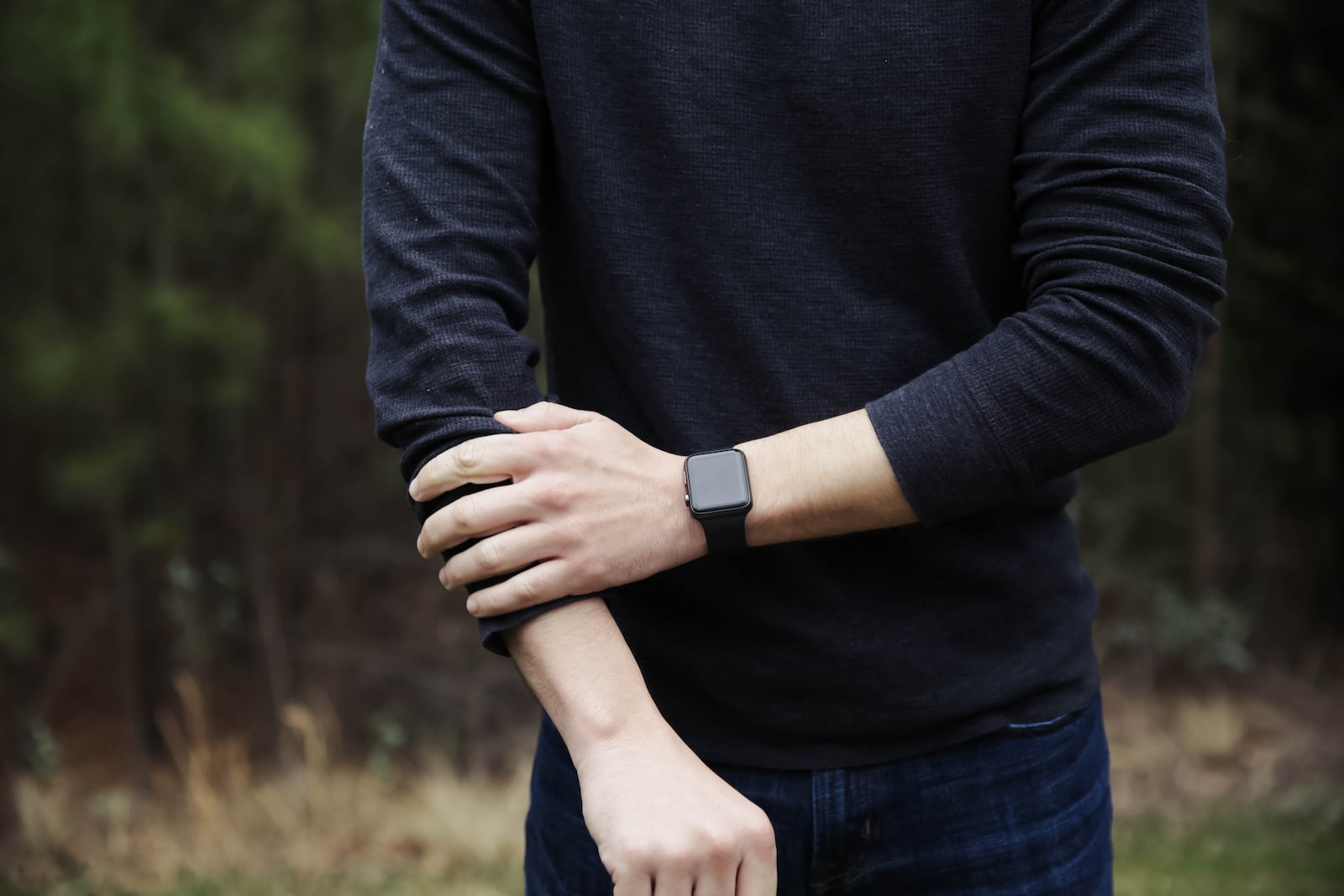 a man in a black shirt is holding his hands together