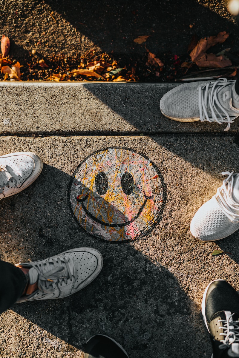 smiley paint on gray ground in front of people